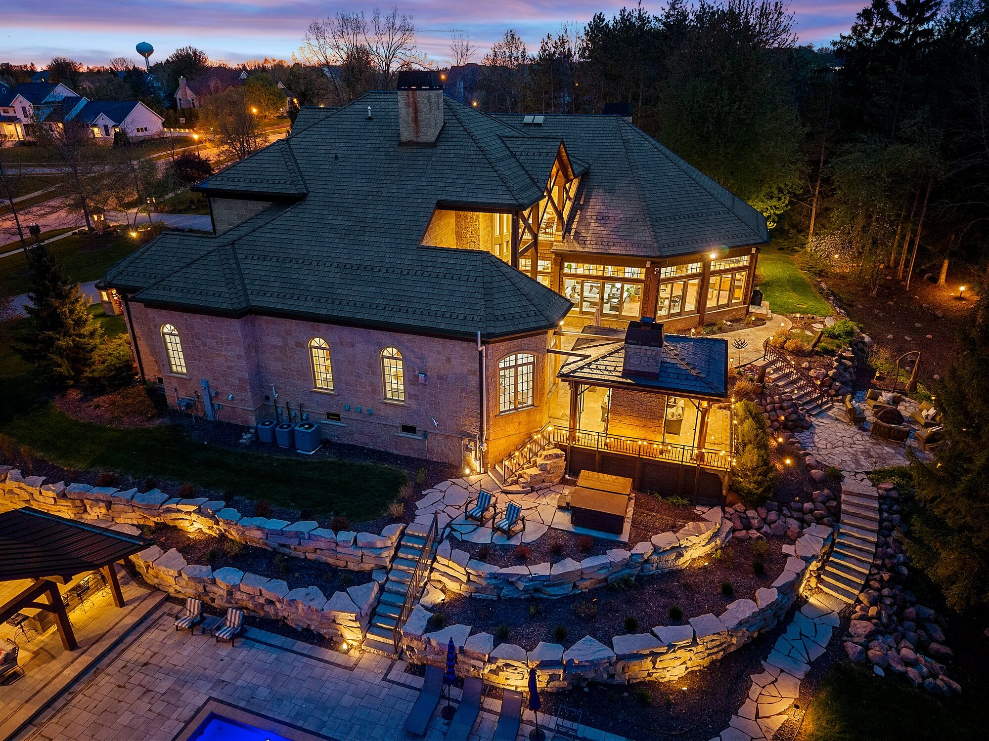 Rear of estate at dusk with landscape lighting