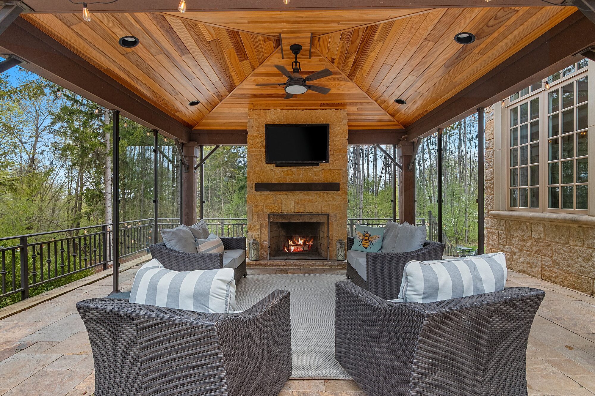 Covered outdoor lounge with stone fireplace